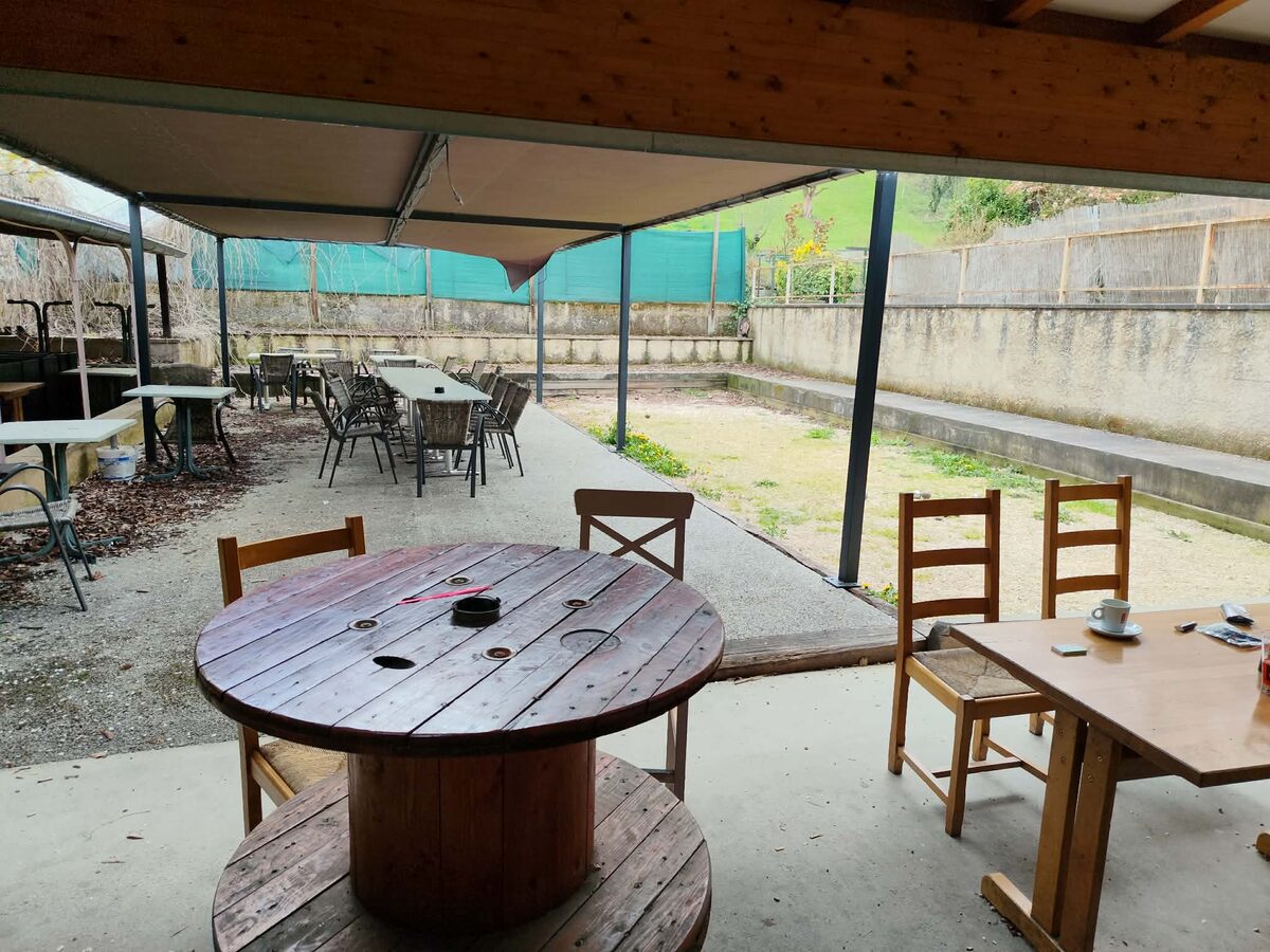 Grande terrasse arriere couverte du Presstabar avec tables en bois